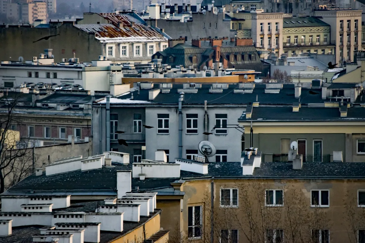 Layered city rooftops and apartment windows seen from above